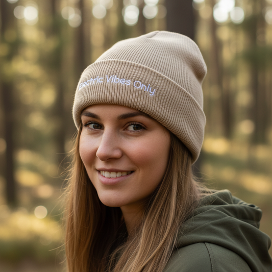 A woman wearing a Beige Cuffed Electric Vibes Only Beanie outside. Three-Quarter View.